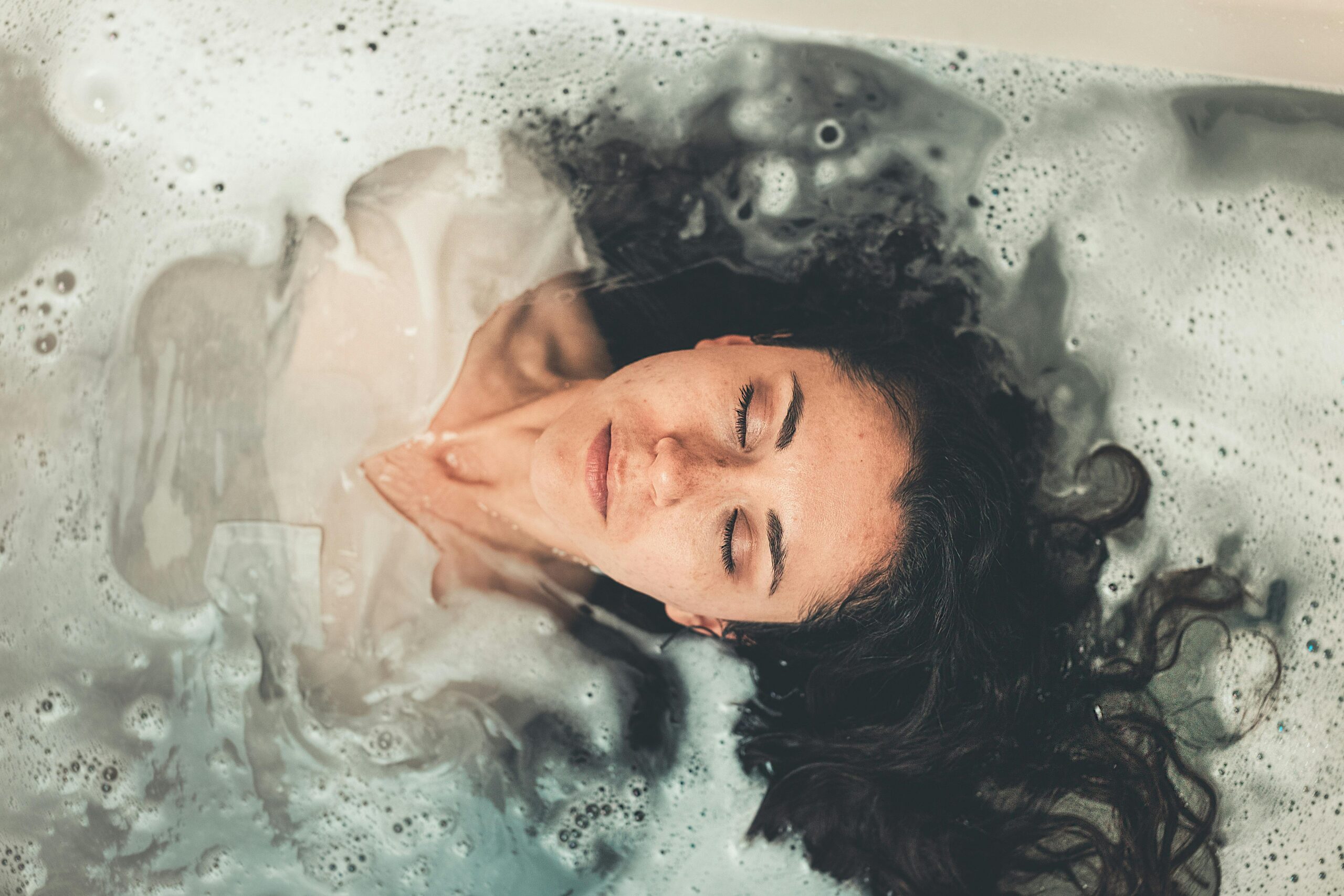 Face of woman relaxing in bubble bath
