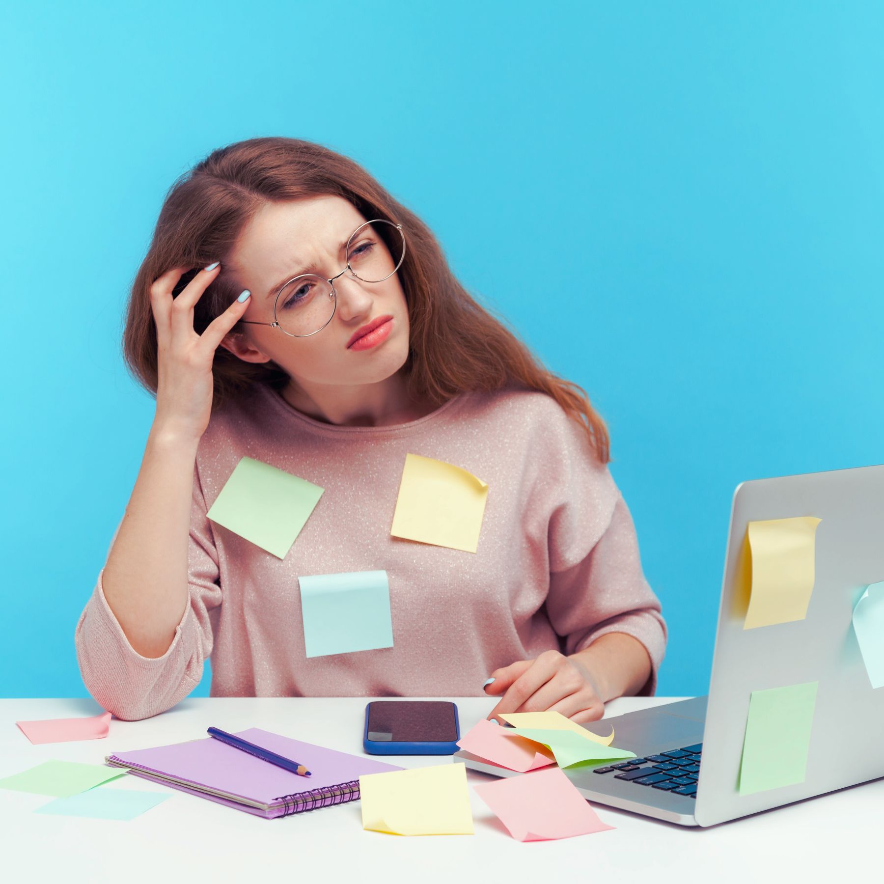 woman covered in sticky notes and looking confused at her computer, adhd